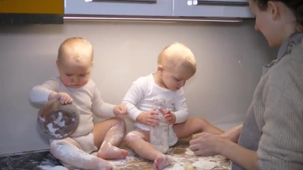 Matka se 2 holčičkami vaří sušenky společně na kuchyňském stole. Věci dělat doma spolu s rodinou — Stock video