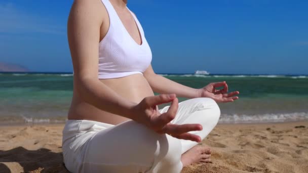 Beneficios de la meditación en la atención prenatal. Mujer embarazada practica la respiración consciente en la playa en verano — Vídeos de Stock