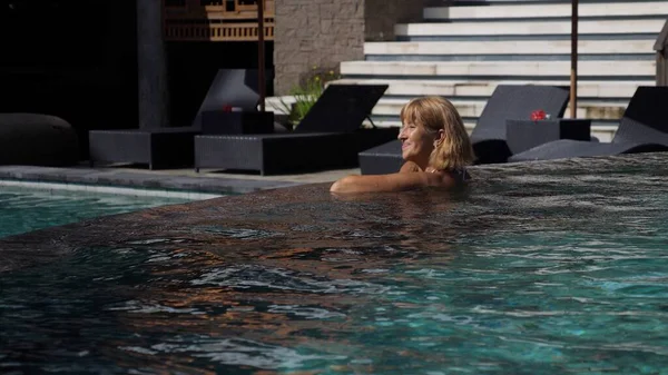 La vita dopo la pensione. Felice donna di mezza età godendo la sua nuotata in piscina — Foto Stock