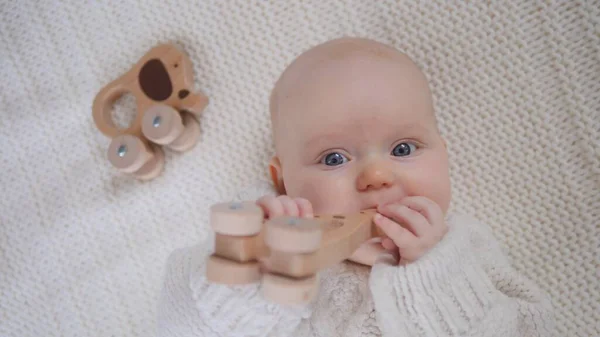 Mignon bébé fille jouant avec en bois Eco Toy porter pull en tricot. — Photo