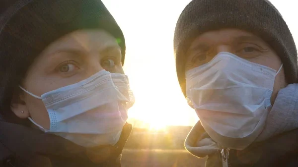 Молодая пара носит защитные маски для лица и целуется на улице. Концепция профилактики распространения вирусов и людей. — стоковое фото