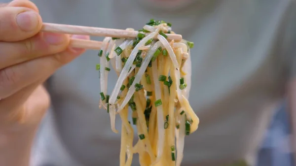 Close up de macarrão escolhido a partir de sopa de ramen vegan com pauzinhos. Opção vegan saudável de sopa japonesa tradicional — Fotografia de Stock