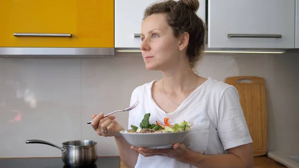 Mujer joven comiendo sano delicioso en su cocina. Alimento casero saludable. — Foto de Stock