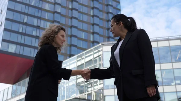 Successful close of a deal between two female office workers with a handshake