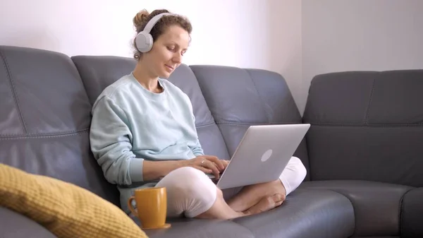 Самоизоляция во время коронавирусного кризиса. Молодая женщина дистанционно работает на ноутбуке на дому настройки — стоковое фото