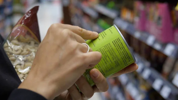 Konserve ürünlerin ayrıntılarını okumak için iki elinizi birleştirin. Bilinçli alışveriş kavramı