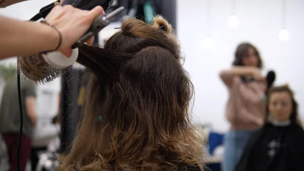 Vue arrière du coiffeur soufflant à sec femme costumer. — Photo