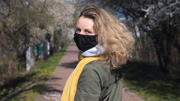 Портрет женщины в маске, гуляющей по улице весной — стоковое фото