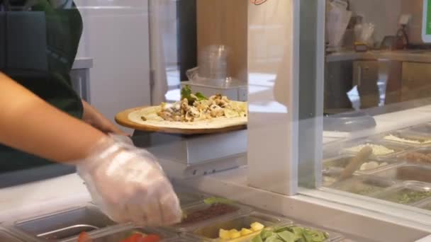 Hand in een handschoen vullen tortilla met gezonde ingrediënten. Veganistisch wikkelen. Gezond straatvoedselconcept — Stockvideo