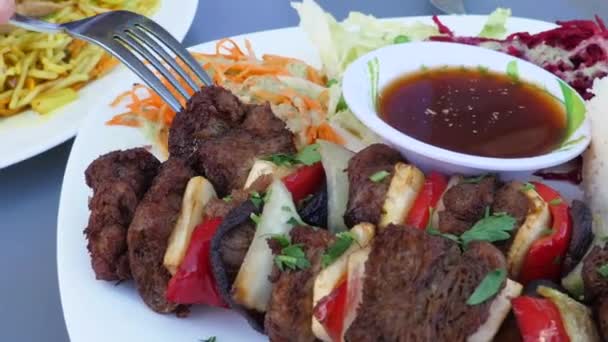 Gebalanceerde veganistische recepten voor barbecuefeestjes. Sluiten van vork dompelen soja vlees stuk in saus op diverse plantaardige plaat — Stockvideo
