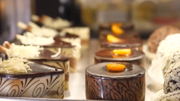 Крупный план выбора шоколадных тортов на выставке в кондитерской — стоковое видео