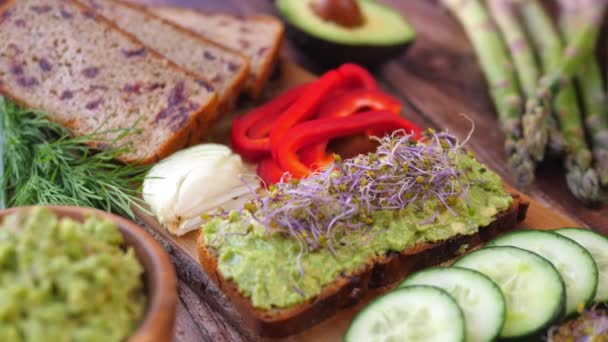 Desayuno Vegano Saludable. Tostadas de Aguacate, Brotes y Verduras. — Vídeo de stock