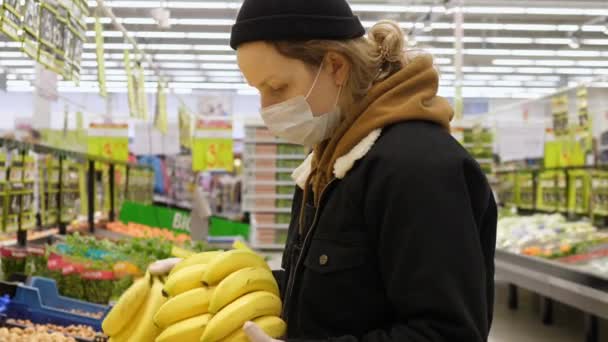 Mujer con máscara en el supermercado, compras durante Coronavirus para frutas. — Vídeos de Stock