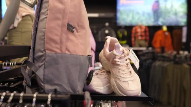Fitness store. Pink training shoes displayed with matching backpack.Customers in the background. Warsaw-Poland-2020 — Stock Video