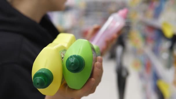 Mujer Comprobación de la etiqueta en el Departamento de Productos Químicos del Hogar en el supermercado. — Vídeo de stock