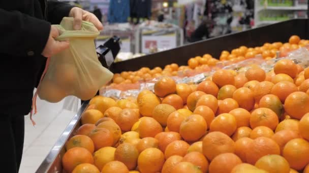 购买带有可重复使用的环保购物袋的橙色水果的妇女。零废物概念、维生素C的免疫力. — 图库视频影像
