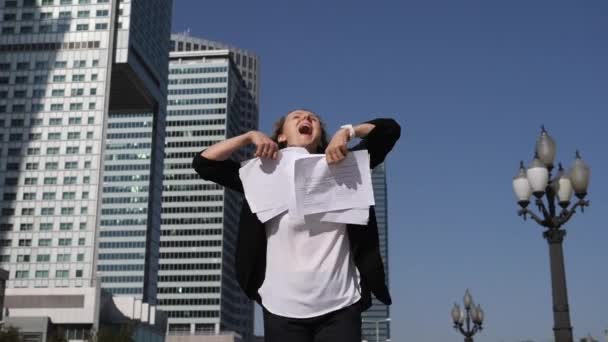 キャリアの成功。エキサイティングな女性は、プロジェクトを完了した後、空気中の紙を投げます — ストック動画