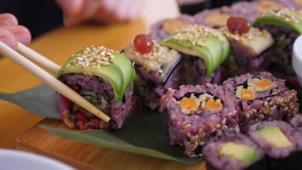 Fata înmoaie rola de sushi în sos de soia înainte de a o mânca . — Videoclip de stoc