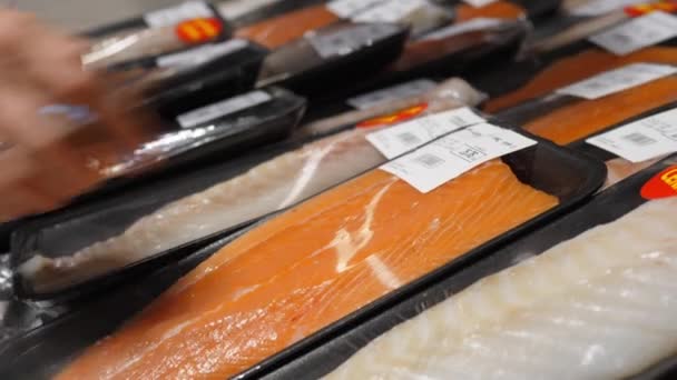 Samičí ruka vybírá filet z lososa v supermarketu. Nákupy mořských plodů — Stock video