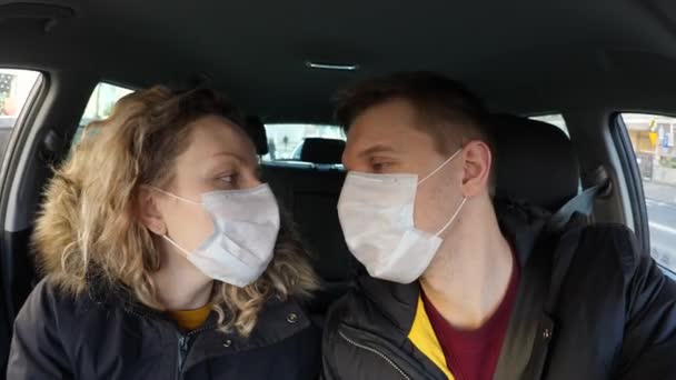 Pár v lásce, muž a žena líbání v ochranné masky v autě. Čínský pandemický koronavirus, ochrana virů. Koncepce znečištění životního prostředí. — Stock video