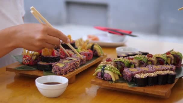 Dva lidé obědvají sushi. Boční pohled na ruce pomocí hůlek jíst sushi set. Japonská kuchyně Artisanu — Stock video