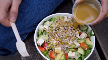 Çiğ vejetaryen salatasını tahini yağıyla tek kullanımlık konteynıra koymanın en iyi görüntüsü. Öğle yemeği molası için sağlıklı atıştırmalıklar. 