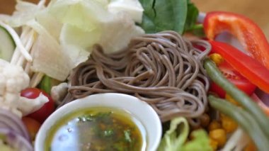 Soba eriştesi, kinoa ve çeşitli sebzelerden oluşan vejetaryen yemek tabağını kapat. Sağlıklı dengeli vegan diyeti