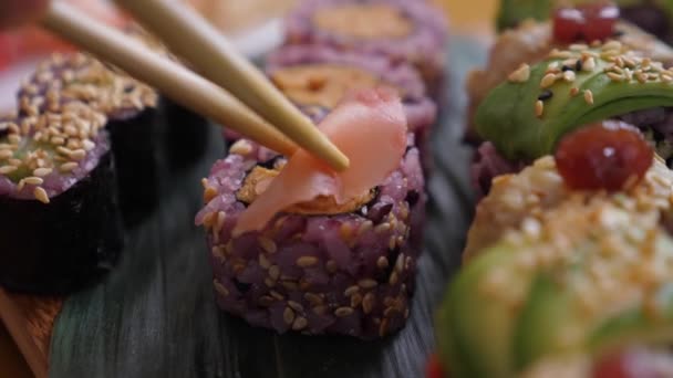 Colocando jengibre en escabeche en el rollo de sushi. Cocina japonesa artesanal — Vídeo de stock