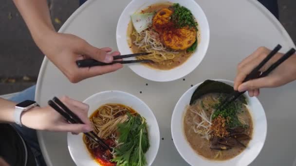 친구들이 둥근 탁자 위에 흰 접시에 세 개의 라멘 수프를 놓고 즐기는 모습 이 눈에 띈다. 건강에 좋은 동양식 개념 — 비디오