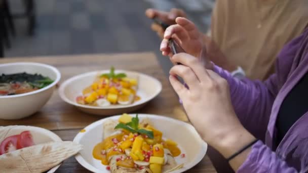 Dos mujeres tomando fotos de su almuerzo vegano con los teléfonos inteligentes. Concepto de estilo de vida vegano saludable. — Vídeos de Stock