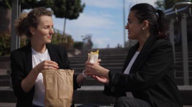 İki bayan meslektaşım güzel bir günde ofis dışında patates kızartması ve burger yiyorlar. 