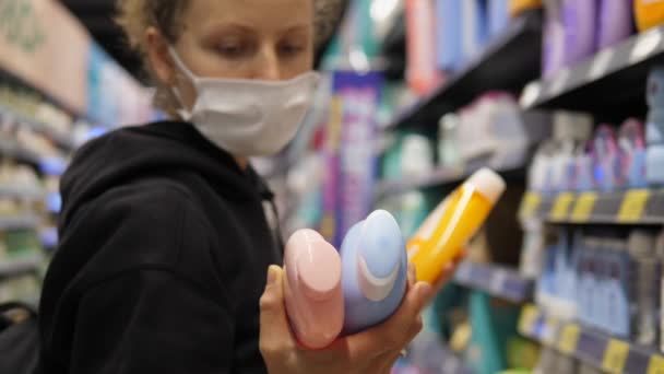 Gromadzenie podczas wybuchu choroby. Kaukaska kobieta w masce twarzy zakupy produktów w sklepie na stanie — Wideo stockowe