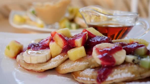 Närbild av pannkakor med frukt och bärsås till frukost. — Stockvideo