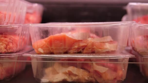 Закрыть сырое красное мясо в пластиковых коробках, выставленных в мясной лавке — стоковое видео