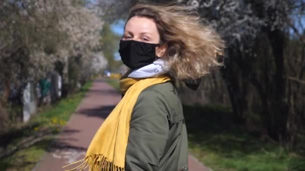 Portret pięknej kobiety w masce chodzącej wiosną ulicą — Wideo stockowe
