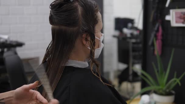 Vista posterior de la mujer en la máscara protectora de la cara conseguir corte de pelo. Segunda ola de pandemia de Covid-19 — Vídeos de Stock