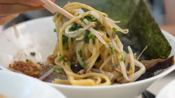 Primer plano de fideos recogidos de la sopa de ramen vegano con palillos. Opción vegana saludable de sopa tradicional japonesa — Vídeo de stock