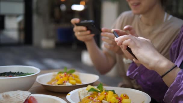 Food blogging. Le amiche scattano foto del loro delizioso e colorato pranzo prima di mangiarlo. Tecnologia e cultura — Video Stock