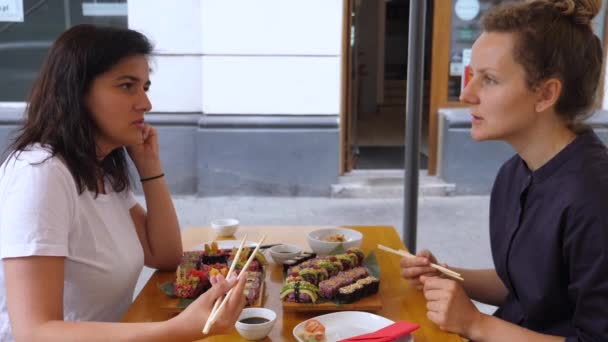 Twee vriendinnen kletsen tijdens hun lunch in een Japans restaurant. Vrouwelijke vriendschap en gezonde voeding. — Stockvideo