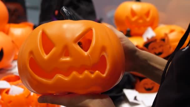 Detailní záběr plastové verze vyřezávané Halloween dýně. Koncept nakupování prázdnin. — Stock video