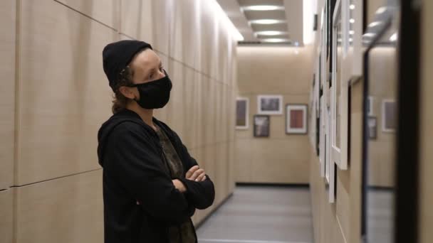 Fotoutställning. Person bär skyddande ansiktsmask överväger konst fotografi — Stockvideo