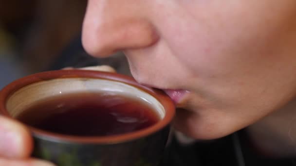 Vrouw blaast op zwarte thee en dinks het uit keramische theekopje. Kunst van thee concept — Stockvideo