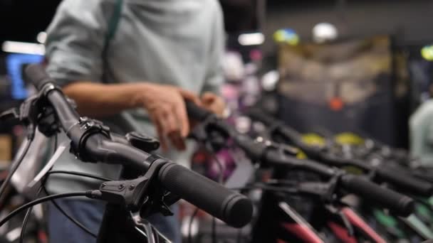Close-up van vrouwelijke handen die fietsremmen testen en de prijs van fietsen controleren in de fietsenwinkel. — Stockvideo