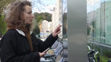 Çevre dostu sıfır karbon toplu taşıma. Bencil paylaşım şeması altında beyaz kadın bisikleti açıyor