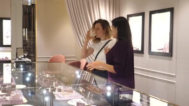 Sprzedawca asystent pomaga młodej kobiecie wybrać biżuterię w luksusowym butiku jubilerskim. Warszawa-Polska-2020 — Wideo stockowe