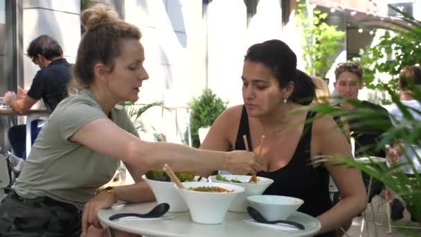 Dos jóvenes alegres probándose sopas veganas de ramen. Tiempo de calidad pasado con amigos. Un estilo de vida vegano saludable. 2020-Varsovia-Polonia — Vídeo de stock