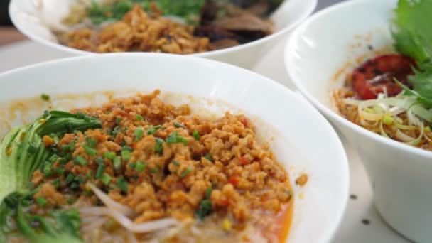 Saludable comida callejera asiática orgánica opciones veganas para una cena o almuerzo.Varios tipos de sopas de ramen veganas servidas con tofu, carne de soja, verduras, champiñones y seeweed — Vídeo de stock