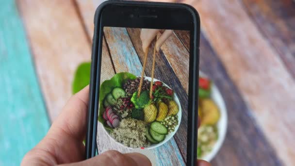 Homme main prend des photos de nourriture sur la table avec téléphone portable. Alimentation végétalienne saine. Photo Smartphone pour les réseaux sociaux Post. — Video