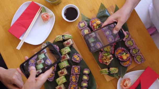 Widok z góry dwóch rąk robienie zdjęć swoich zestawów sushi ze smartfonami. Artisan kuchnia japońska — Wideo stockowe