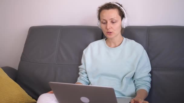 Reunión en línea durante la pandemia de covid-19. Mujer caucásica teniendo conversación remota a través de la plataforma en la nube para llamadas de vídeo y audio — Vídeo de stock